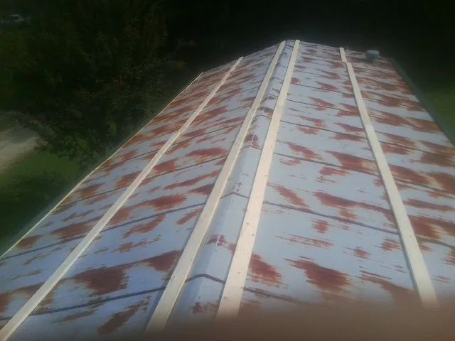 Rusted metal roof panels with new wood purlins before replacement — Storm Damage Roof Repair in Chanhassen by Roofing Brothers