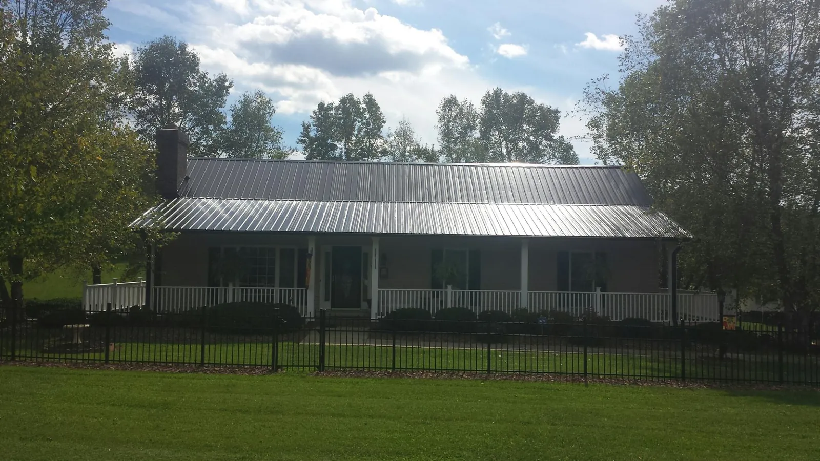 Gray metal roof on a brick ranch with a full width front porch — Gutter Guard Installation work by our crew in Chanhassen